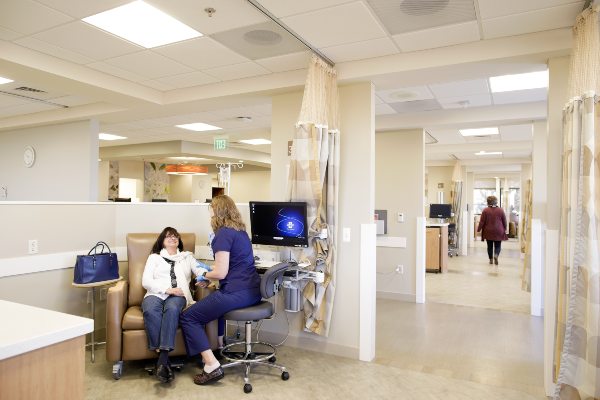 Someone receiving infusion treatment in a bright, clean medical clinic