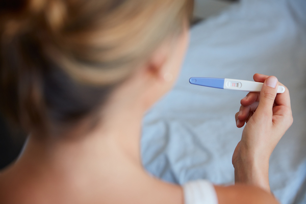 Woman holding a positive pregnancy test Woman holding a positive pregnancy test
